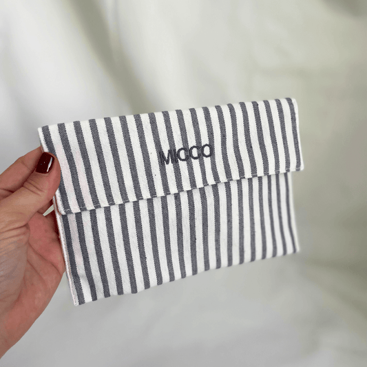 Monedero mediano rayado gris oscuro y beige, tipo sobre, ideal como organizador de viaje o para el bolso
