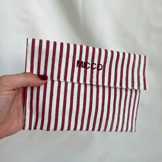 Cartera mediana con rayas burdeos, cierre magnético y acabado forrado 