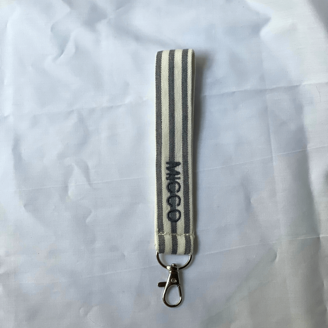 Llavero rayado gris oscuro y beige, de algodón, con anilla resistente