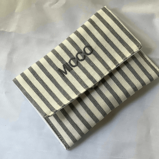 Mini cartera rayada en gris con cierre magnético y diseño plano